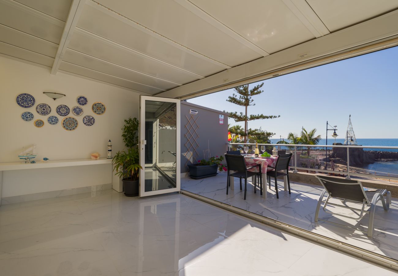 Salón abierto a terraza con vistas al mar playa mogán